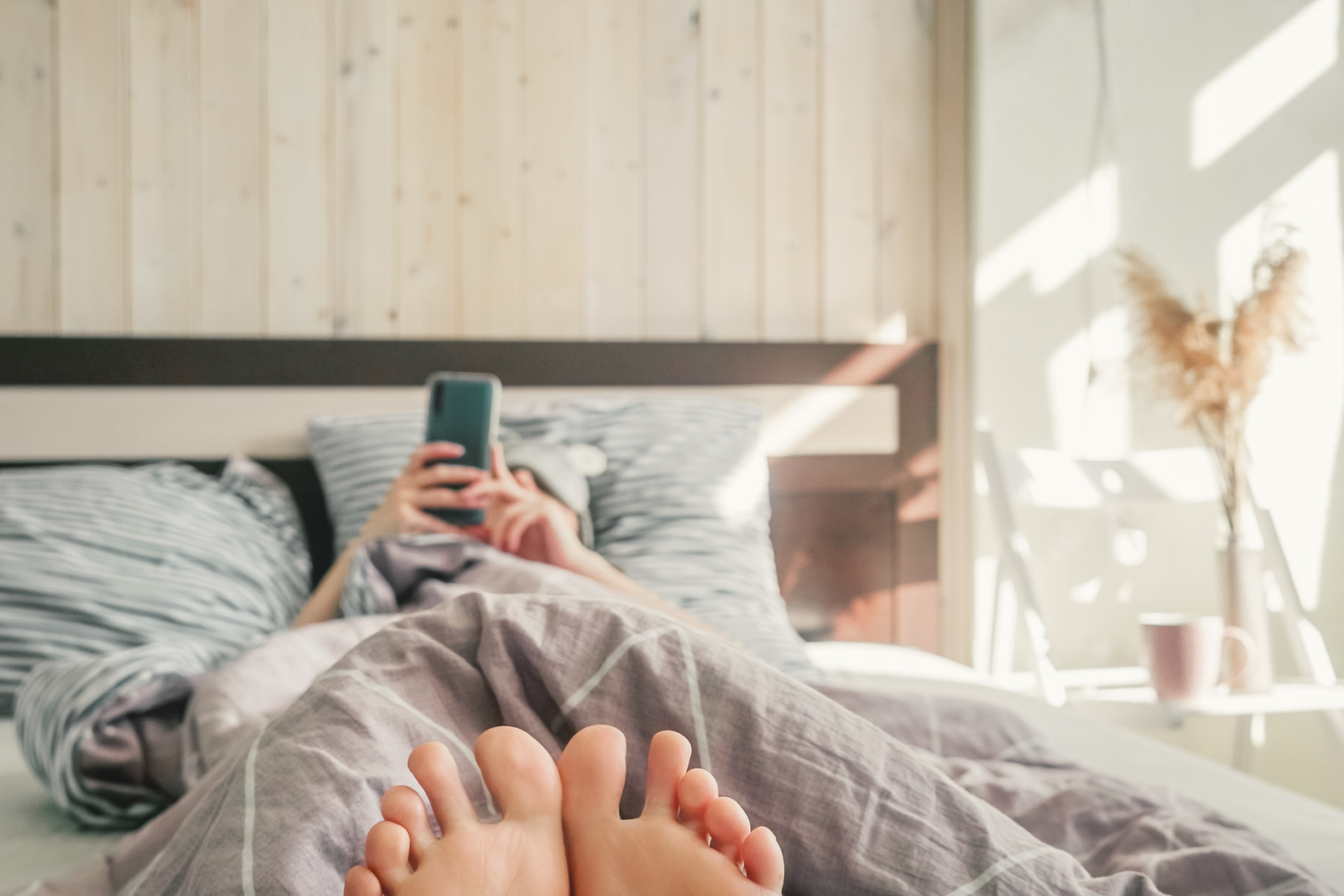 Woman with Cell Phone in Her Bed.
