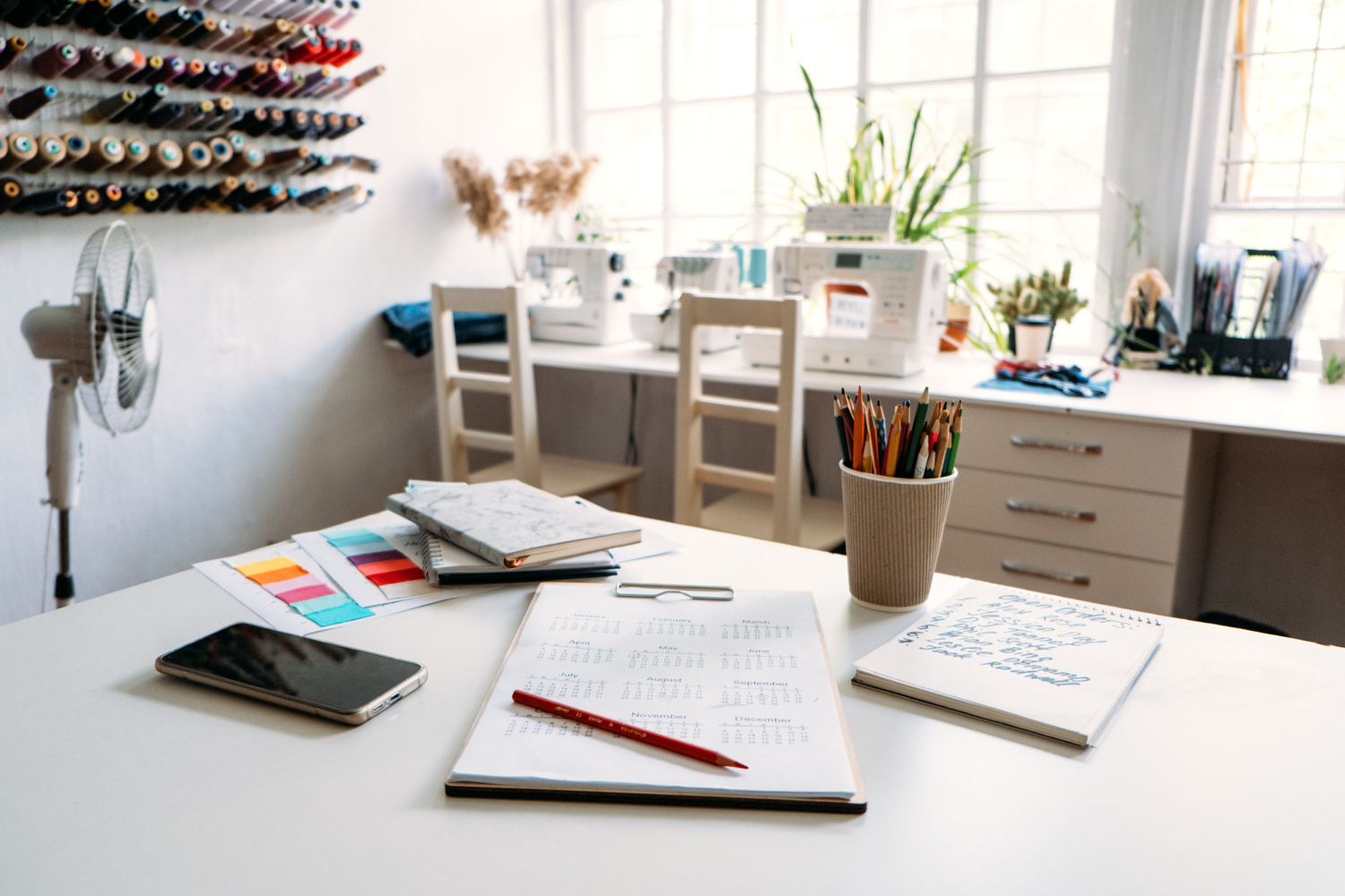Small Business, Sewing Dressmaker Studio. Fashion Designer Working Studio, with Mannequin, Thread Spools and Sewing Machines. Notepad with Orders and Calendar on Sewing Studio Background